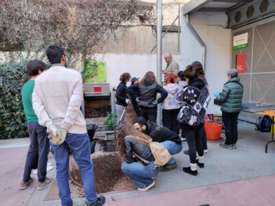 Imatge de la darrera jornada d¡obtenció de compost al Punt Verd de Barri Vallcarca, amb un grup nombrós de persones durant el procés d'obtenció del compost.